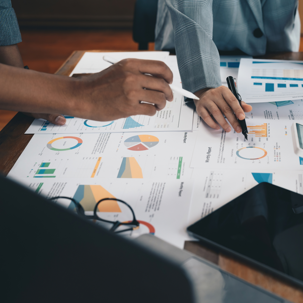 team surrounding paper on a desk looking at strategy together